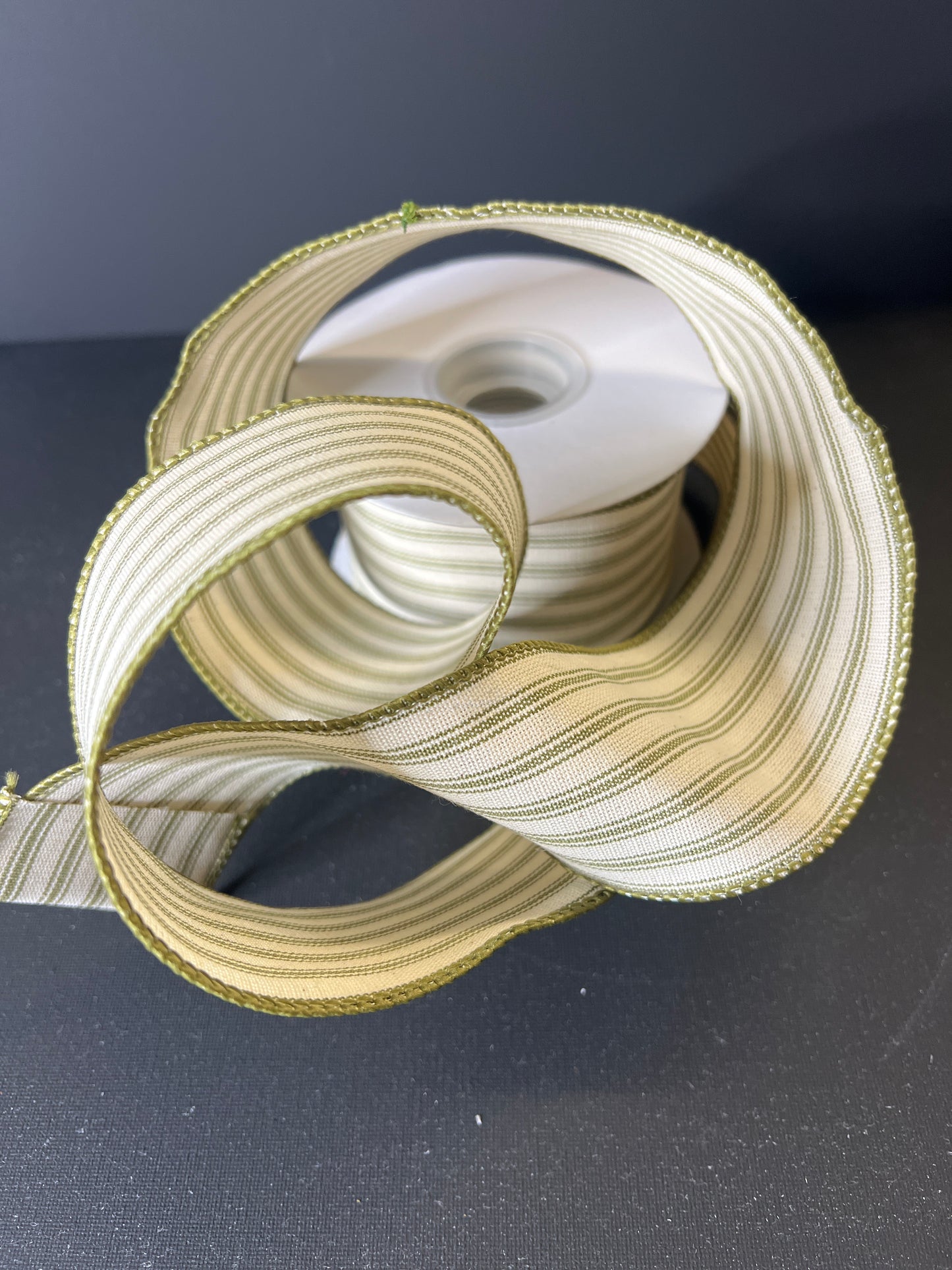 Close-up of a spool of gold ribbon on a dark background