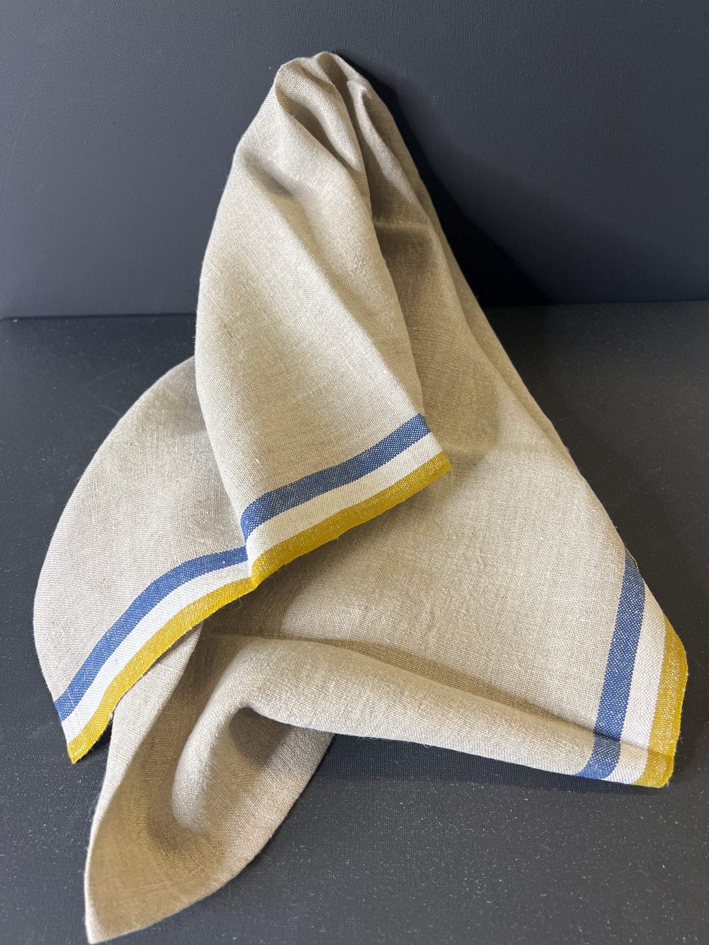 Beige fabric with blue and yellow stripes on a dark background