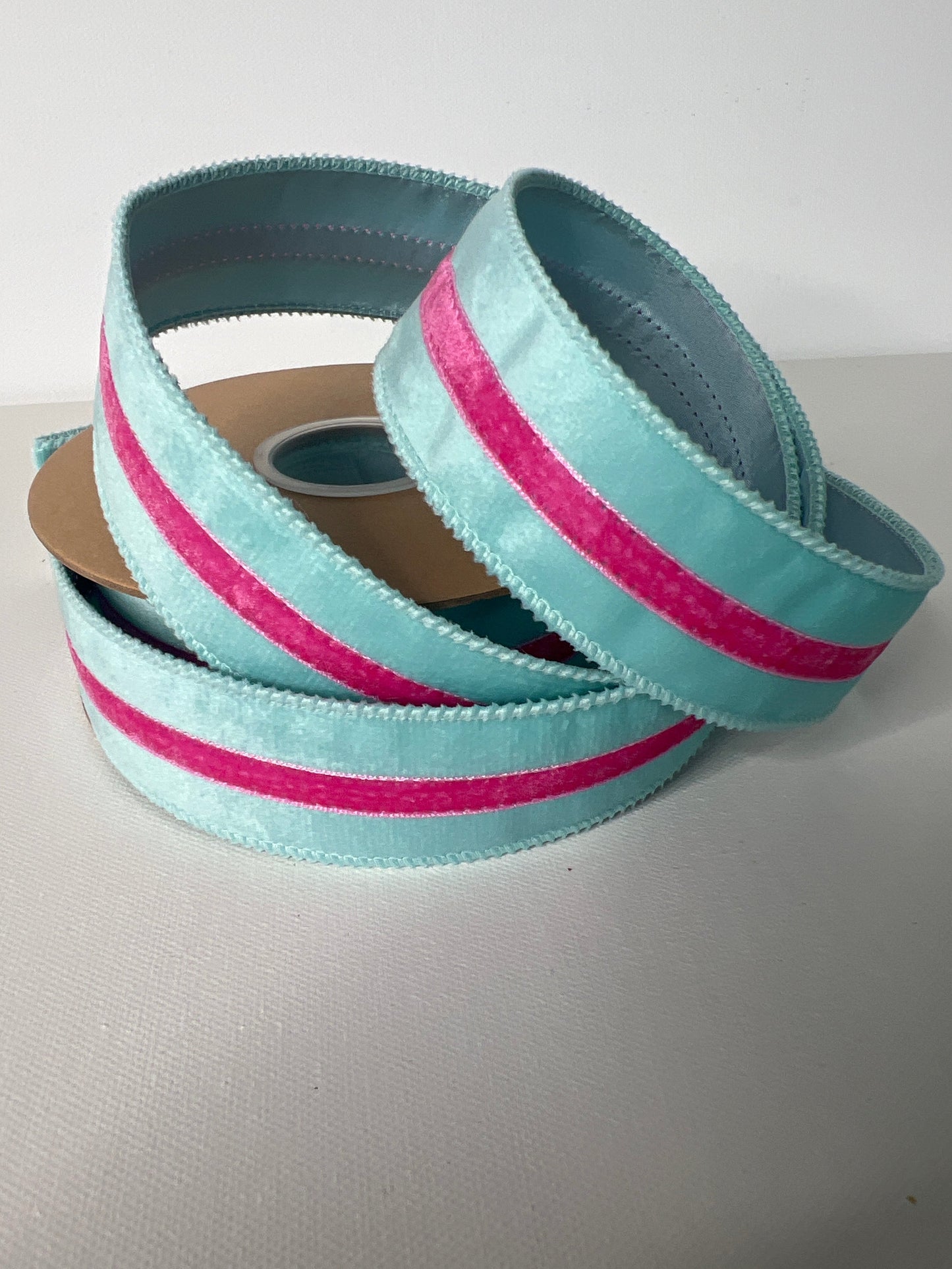 Light blue ribbon with pink stripes on a white background
