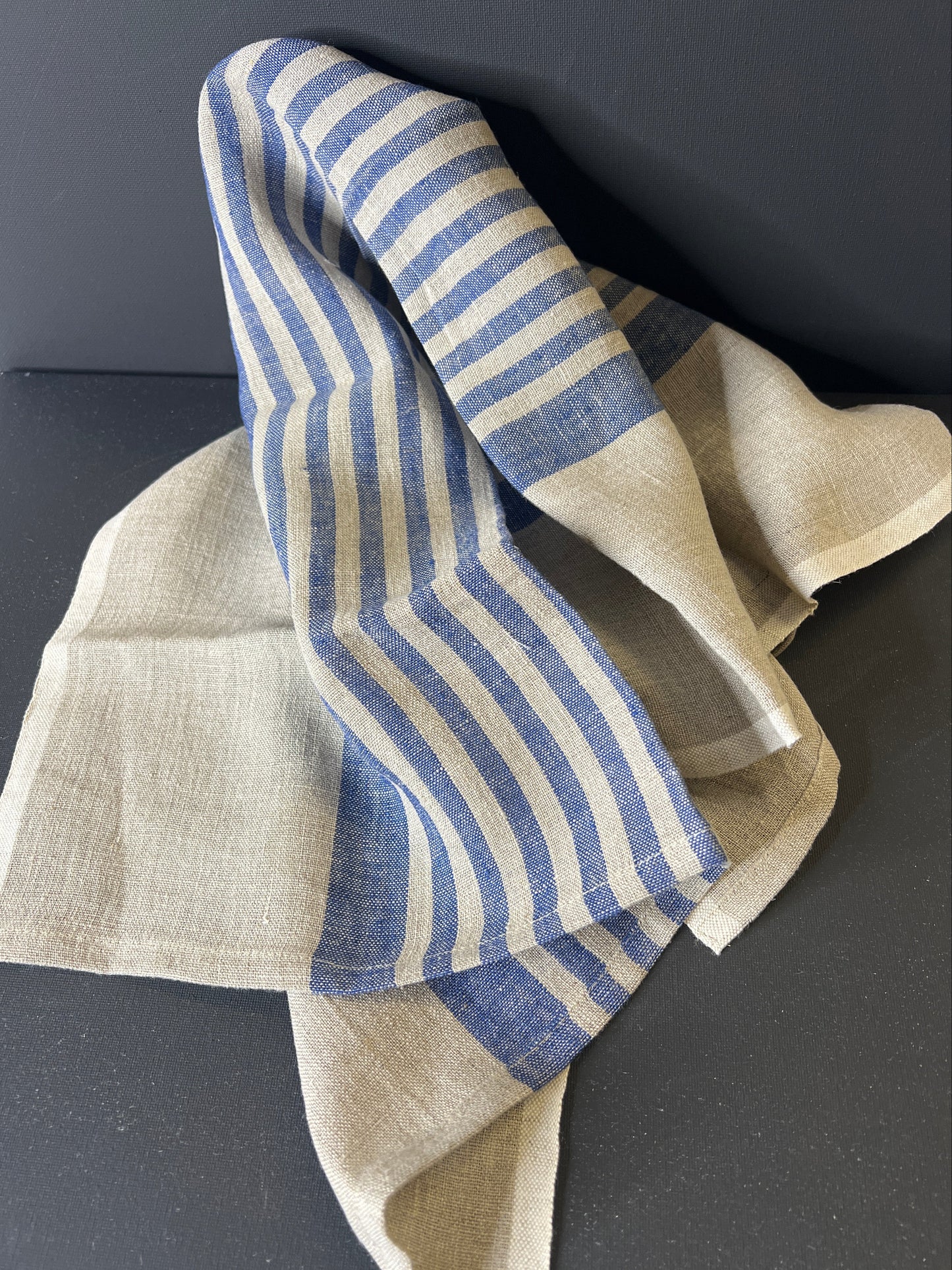 Beige and blue striped fabric on a dark background
