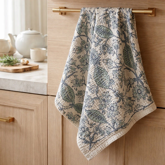 Floral patterned towel hanging on a wooden cabinet in a kitchen setting.