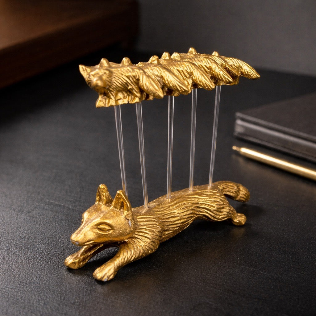 Gold fox-shaped holder with multiple spikes on a dark surface