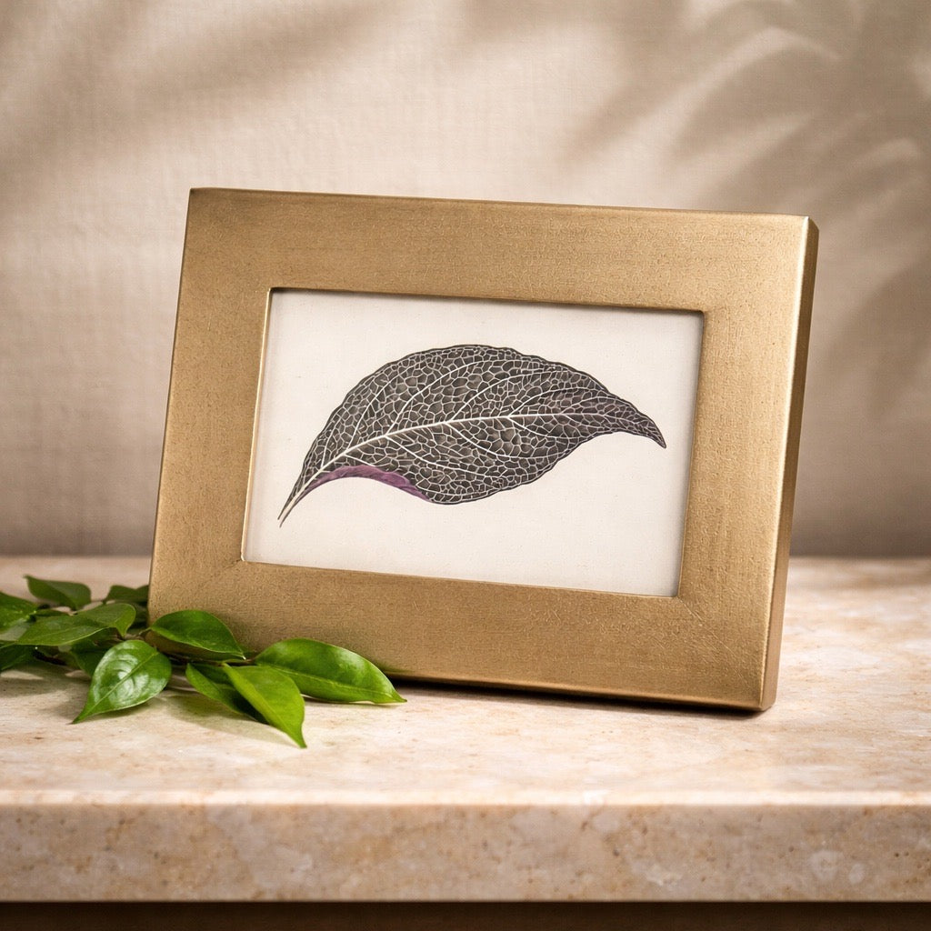 a gold frame on a wooden surface.