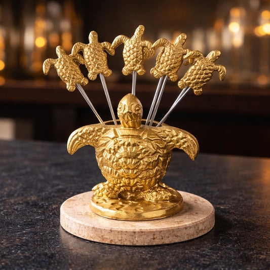 Gold turtle-shaped cocktail pick holder on a dark surface