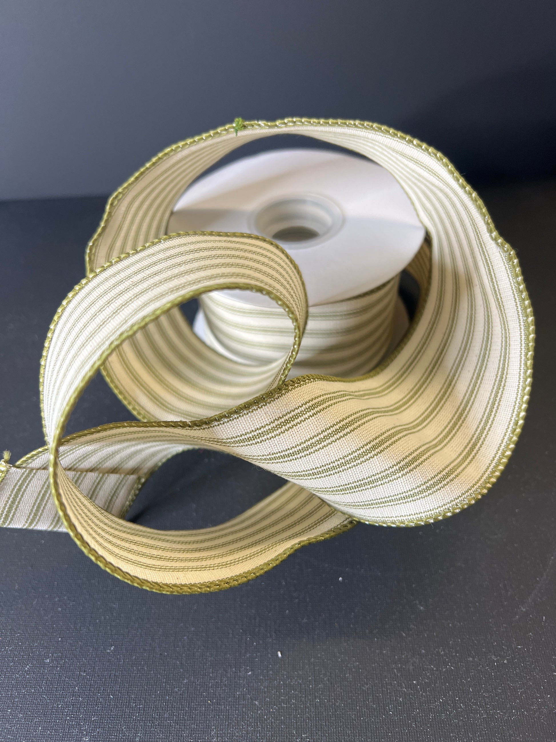 Close-up of a spool of gold ribbon on a dark background