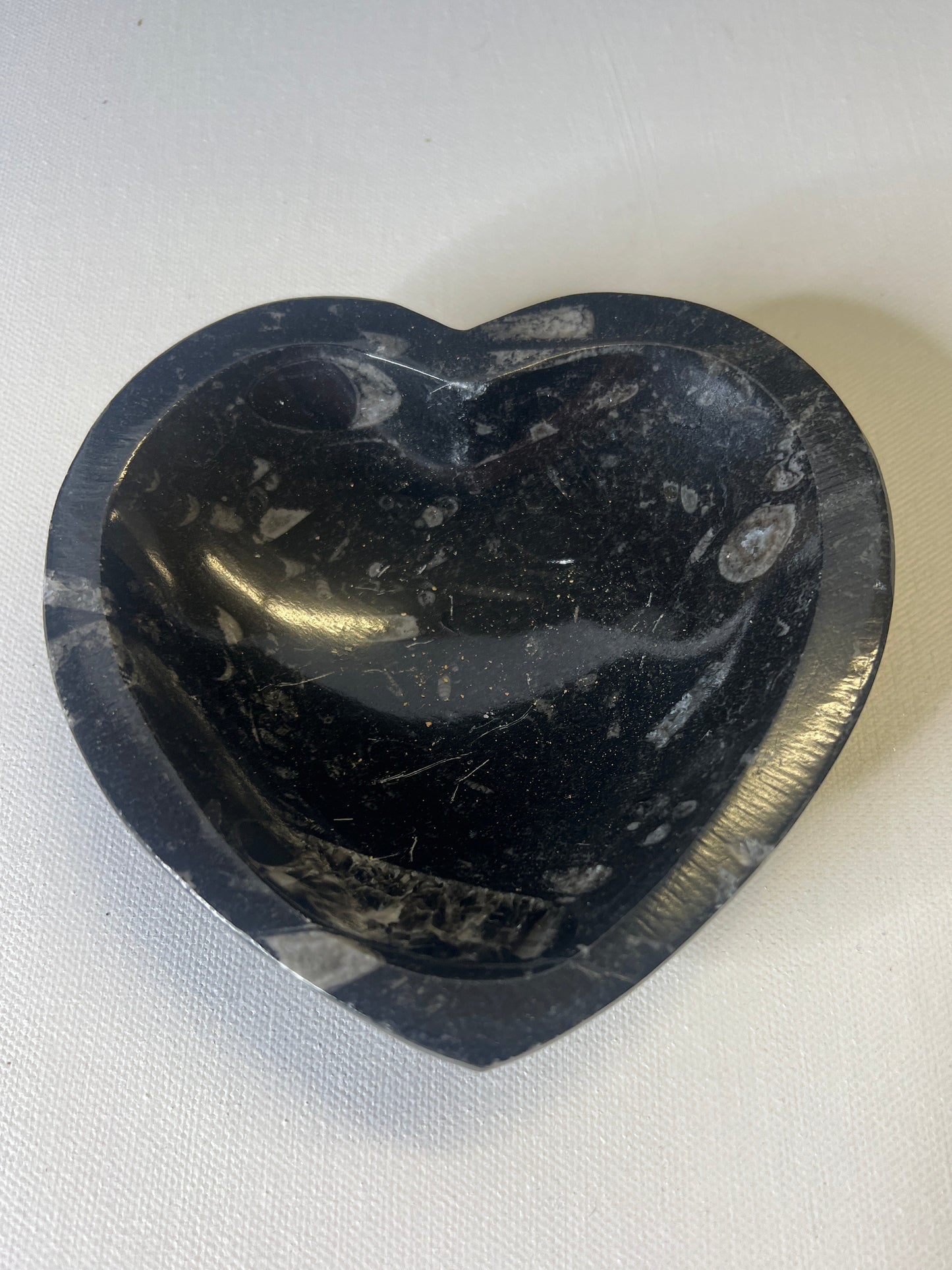 Black stone with a unique pattern on a white fabric background